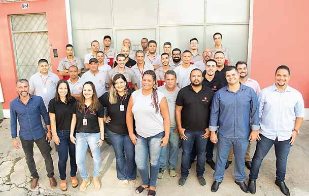 Equipe completa da Embelezart Elevadores reunida na fachada da sede da empresa no Rio de Janeiro